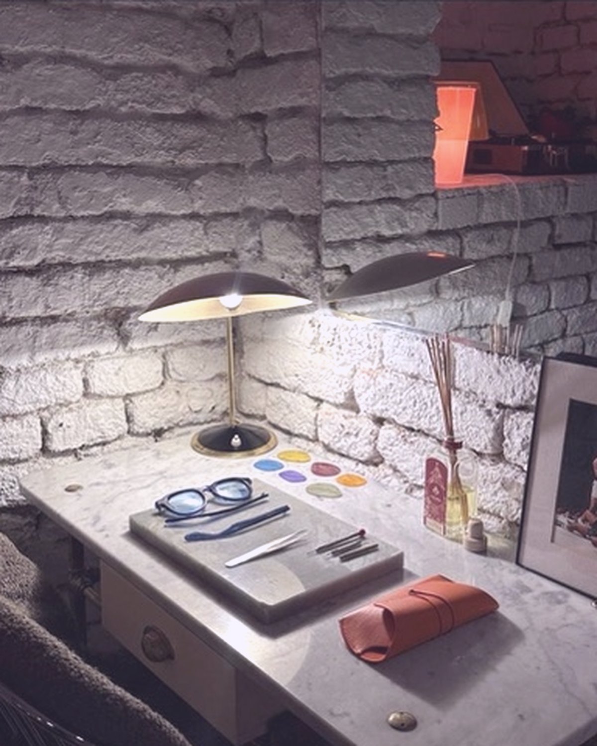 A marble worktable with glasses, objects and warm light